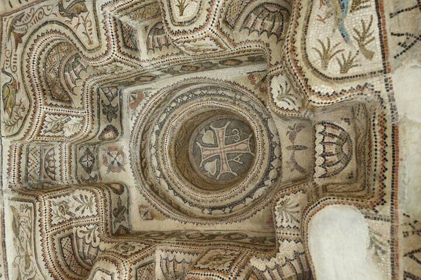 A detailed mosaic with geometric patterns and a central circular design. 1