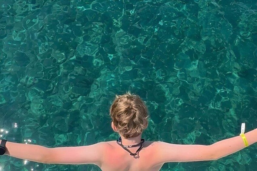 Una persona con los brazos extendidos en agua cristalina. 5