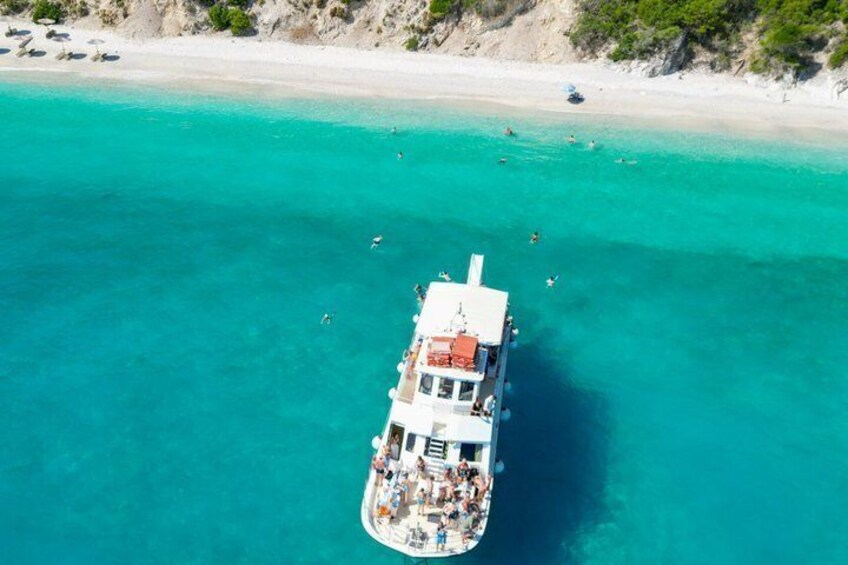 A boat with passengers on a turquoise sea near a sandy beach. 2