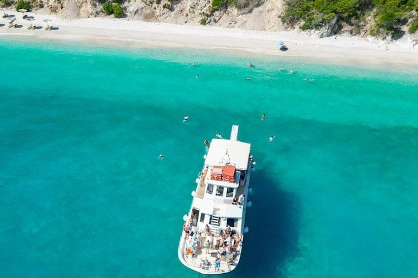 A boat with passengers on a turquoise sea near a sandy beach. 2
