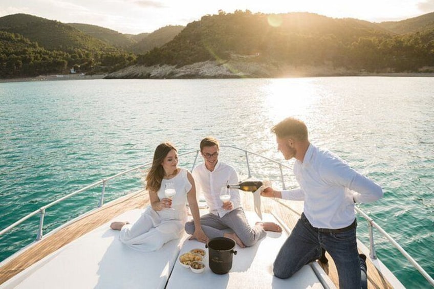 A boat with three people sitting on the deck, a body of water, and a hilly landscape in the background. 1