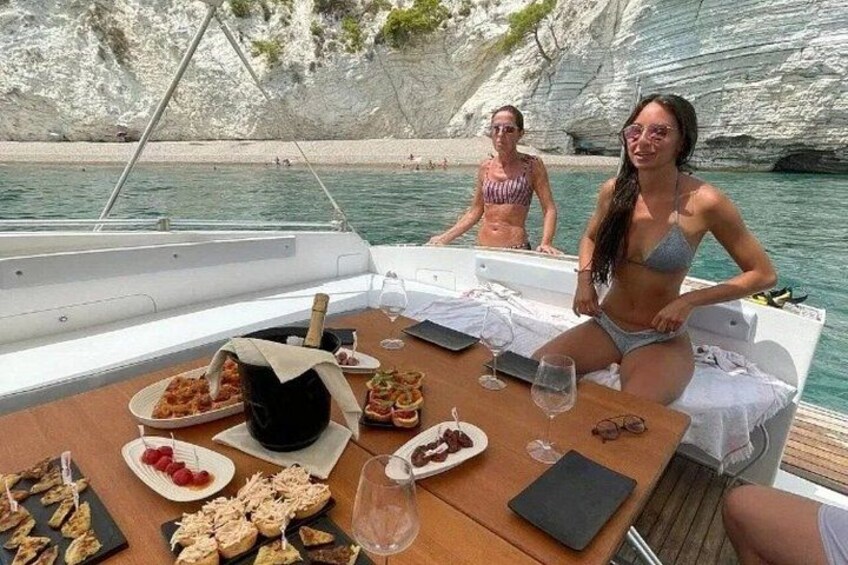 A boat with a table set for a meal, surrounded by rocky cliffs and calm water. 3