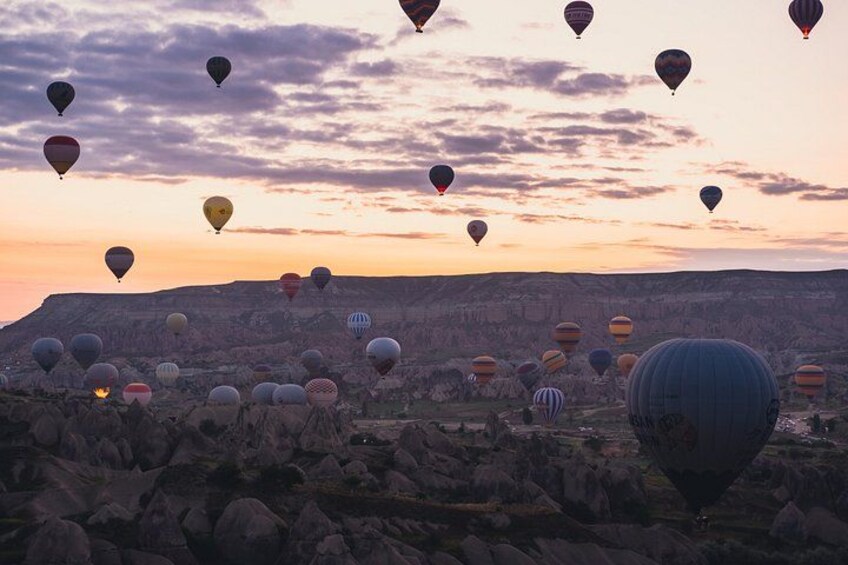 A landscape with numerous hot air balloons at sunset. 2