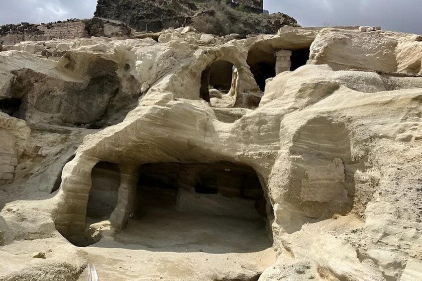 Rock formations with caves and a distant mountain. 3