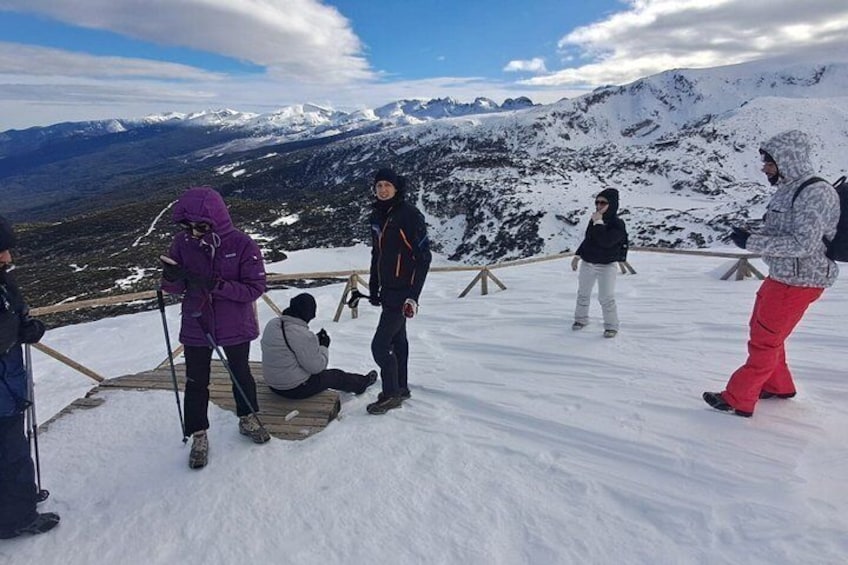 A group of people on a snowy mountain with a clear sky and distant mountains. 2
