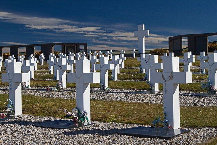 A cemetery with numerous white crosses and headstones. 3