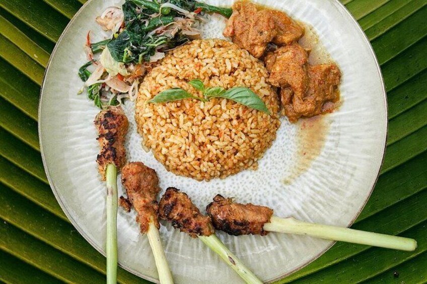 A plate of food with rice, grilled meat, and vegetables. 4