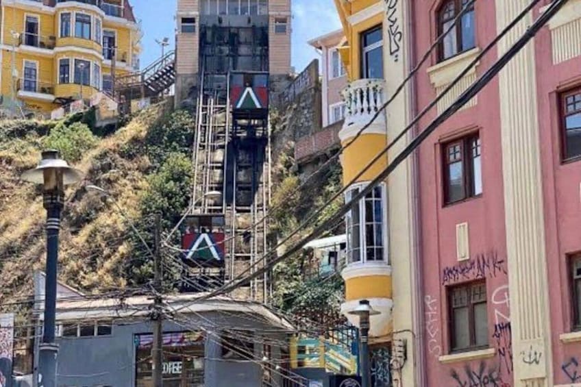 A street with a tram, buildings, and a hill. 5