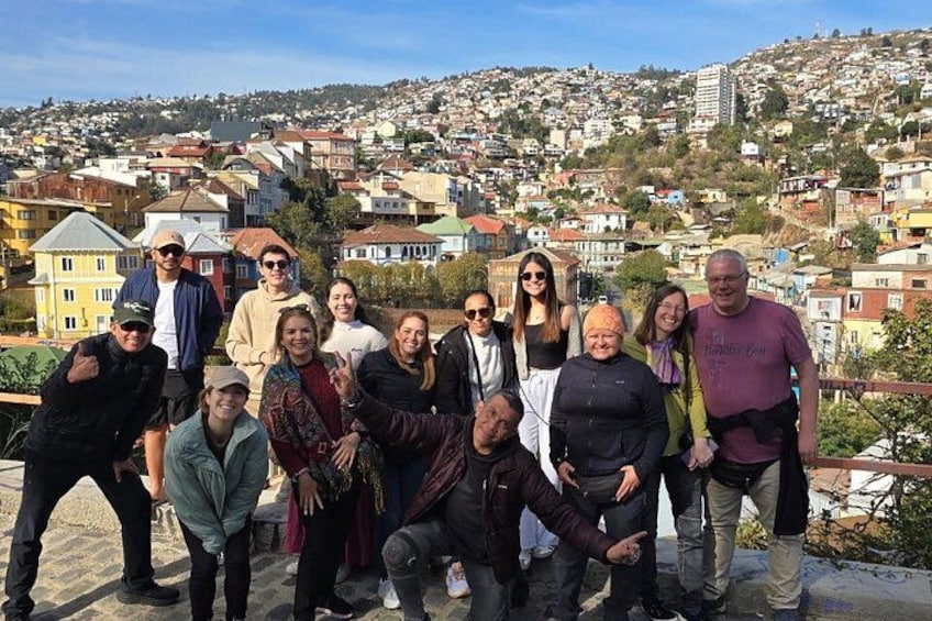 A group of people posing on a rooftop with a cityscape in the background. 2