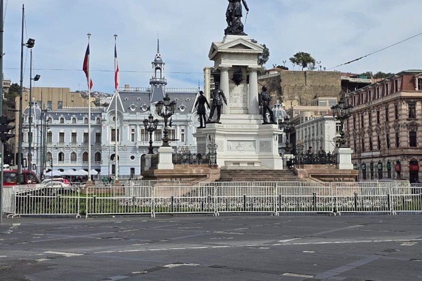 A statue in a plaza with buildings in the background. 4