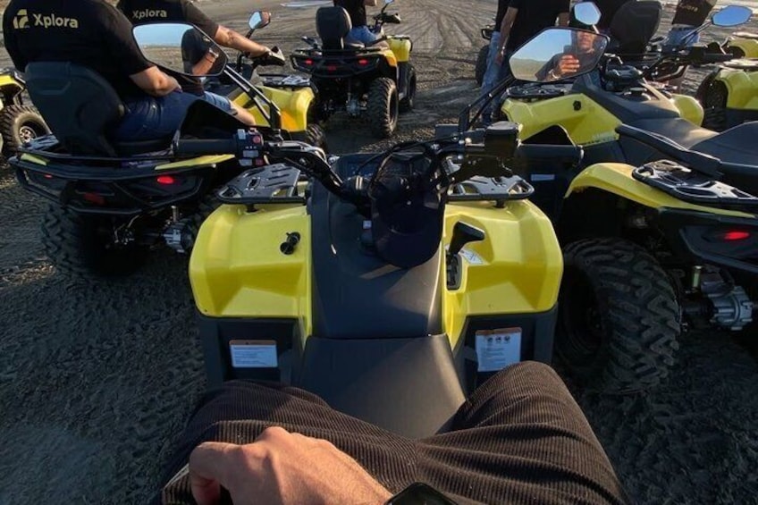 Een persoon zit op een gele quad met een zwarte stoel, omringd door soortgelijke quads. 2