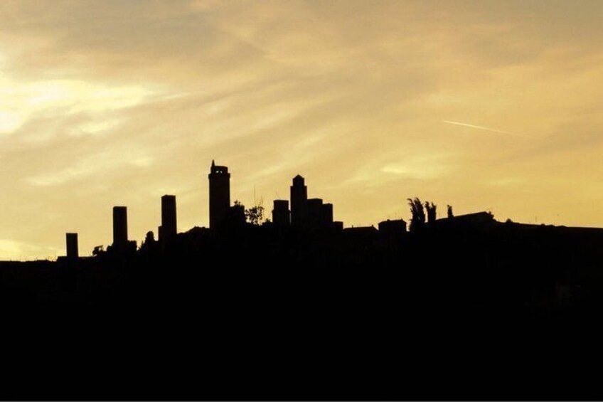 A city skyline silhouette against a sunset sky. 2