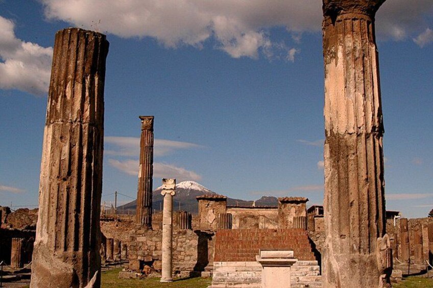 Ancient ruins with columns and a mountain in the background. 4