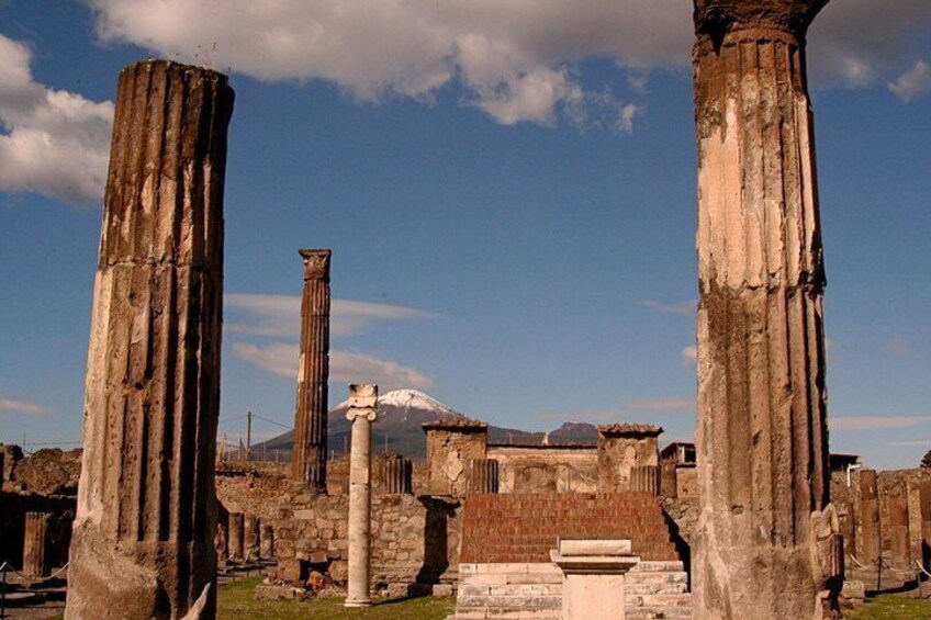 Ancient ruins with columns and a mountain in the background. 4