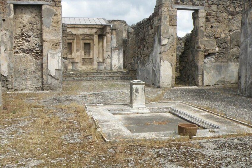 An ancient ruin with stone walls, a central square, and a doorway. 5