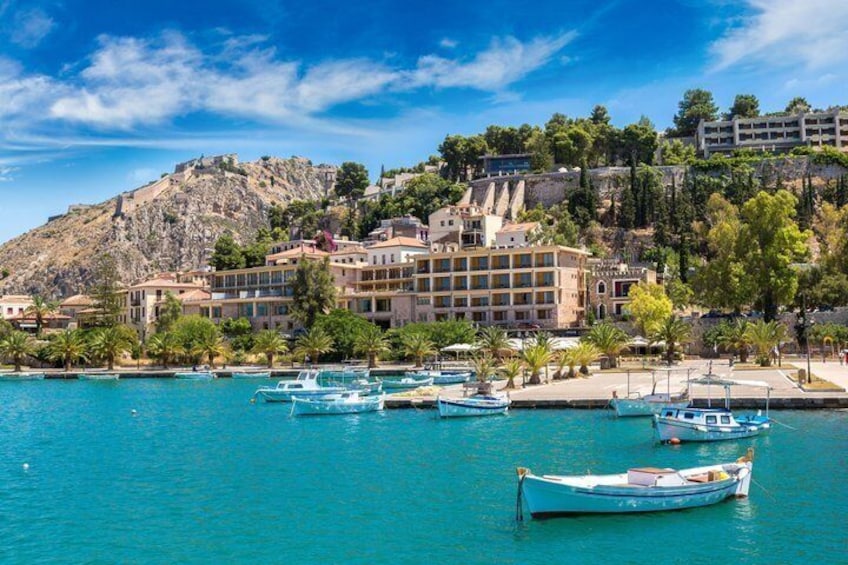 A coastal town with a marina, boats, and buildings on a hillside. 4