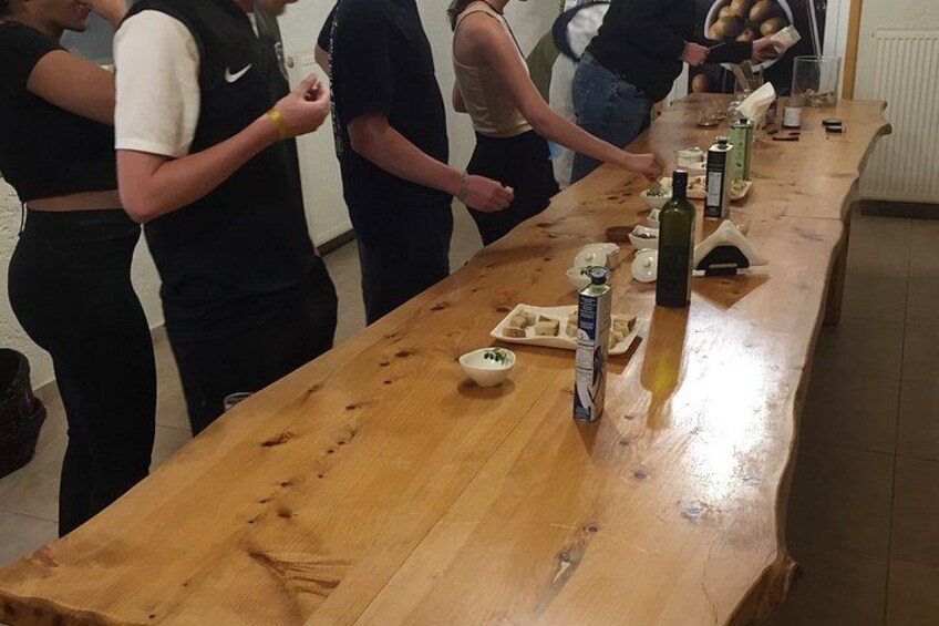 Una larga mesa de madera con comida y botellas. 2