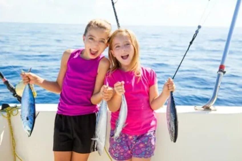 Two individuals holding fish on a boat with the ocean in the background. 1
