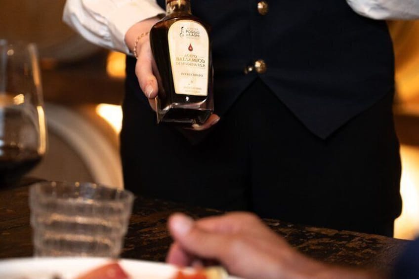 A person holding a bottle of Balsamic Vinegar. 2