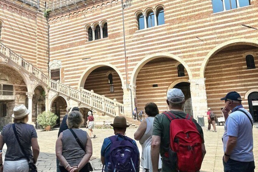 A historic building with arched doorways and a central staircase. 5