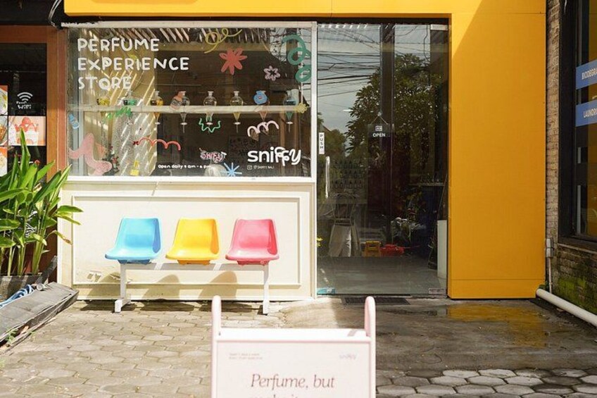 A perfume store with colorful chairs outside. 2