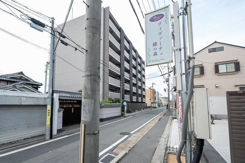 A street with a multi-story parking garage, utility poles, and a building with signage. 2