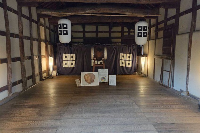 A traditional Japanese room with tatami flooring, shoji screens, and a central display of cultural artifacts. 3