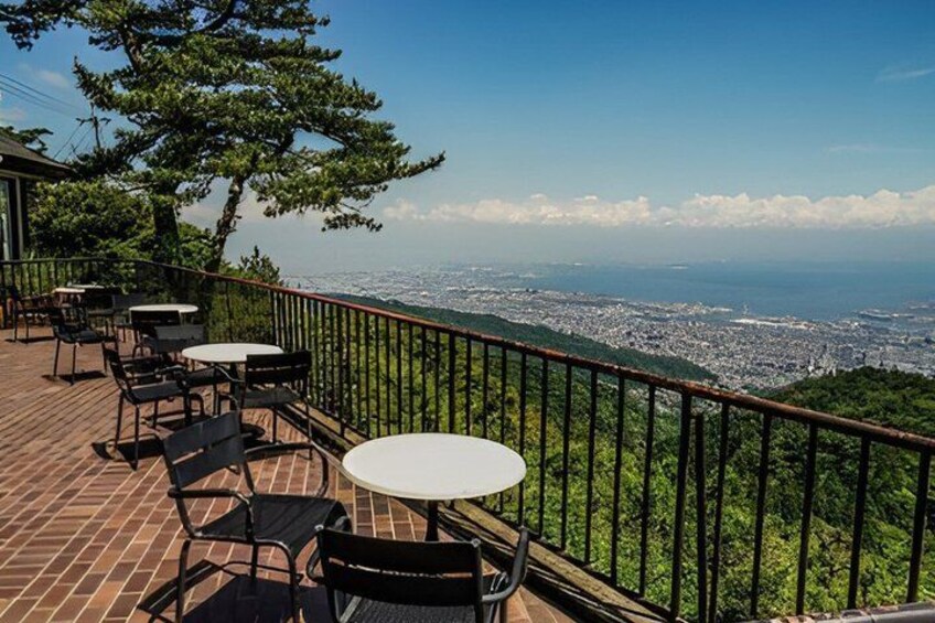A terrace with tables and chairs overlooking a cityscape. 2