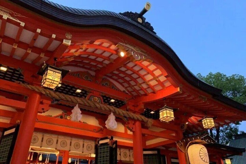 A traditional Japanese temple with red pillars, a curved roof, and hanging lanterns. 3