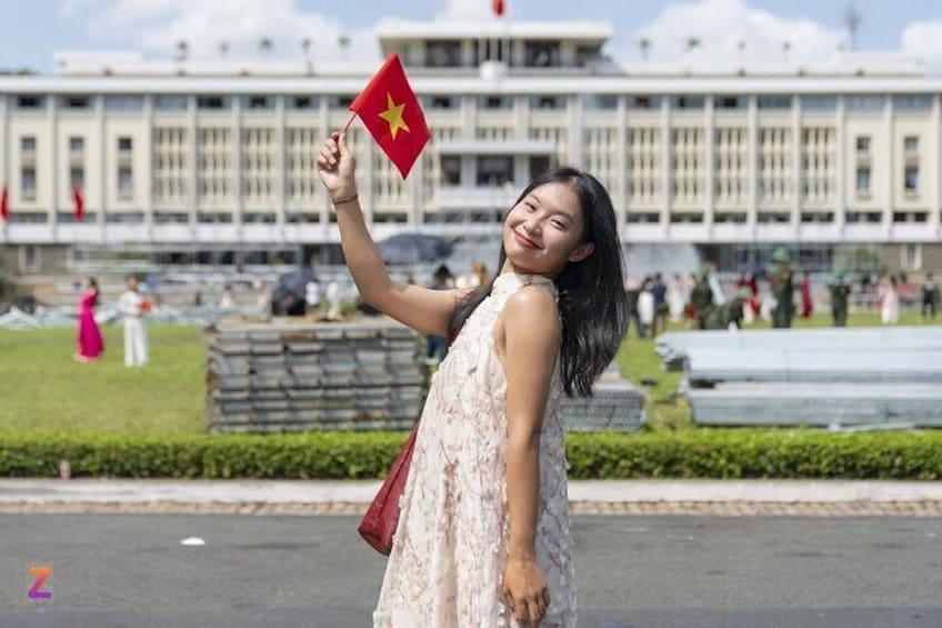 Une personne tenant un drapeau devant un grand bâtiment orné de colonnes. 1
