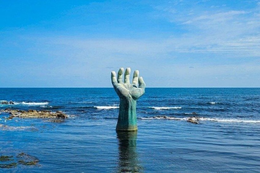 A large hand sculpture in the ocean. 3