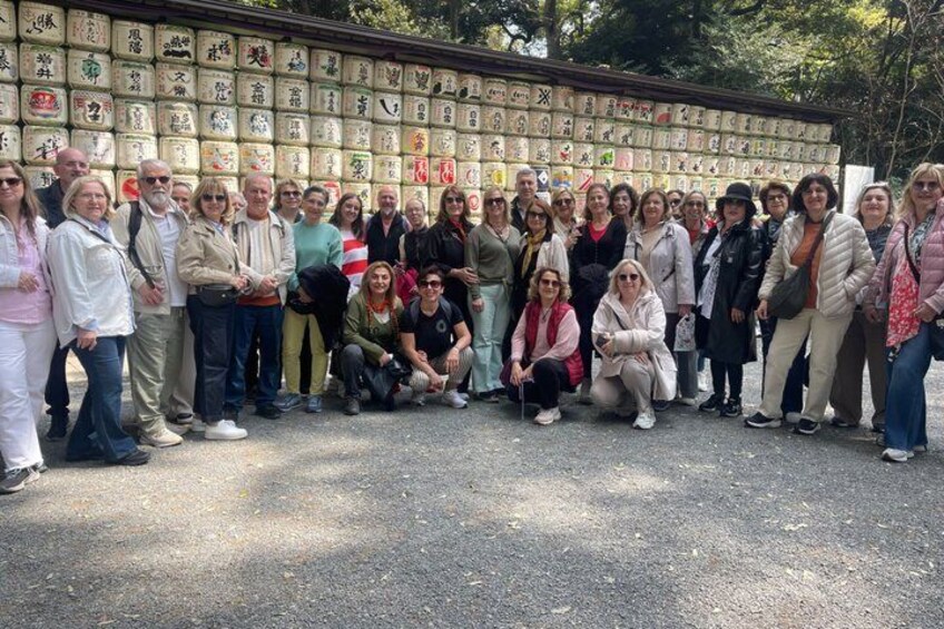 Un gruppo di persone che posano di fronte a un muro con numerose targhe commemorative. 4