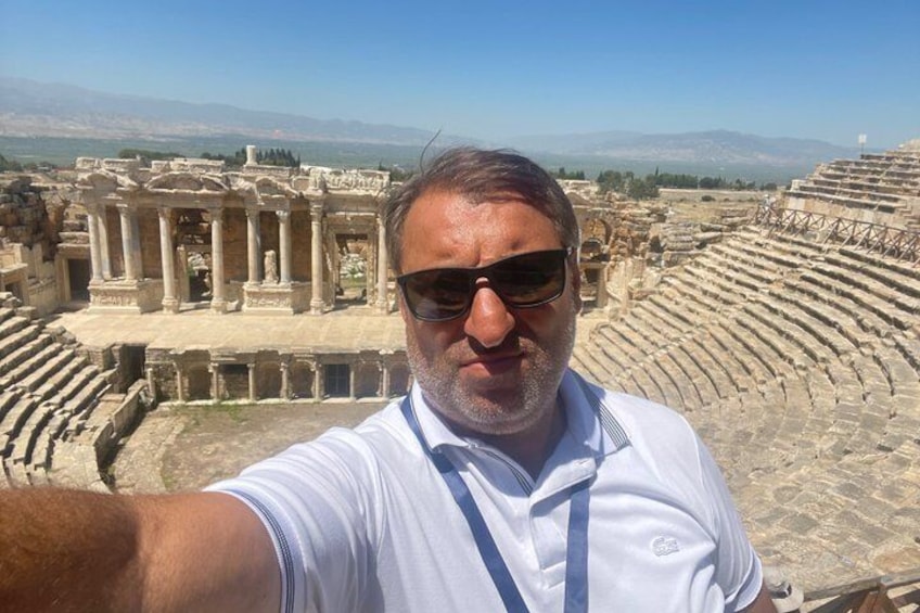 Un uomo si scatta un selfie con rovine antiche e un anfiteatro sullo sfondo. 5