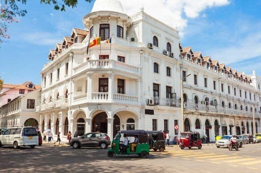A white colonial-style building with multiple balconies and arched windows. 4