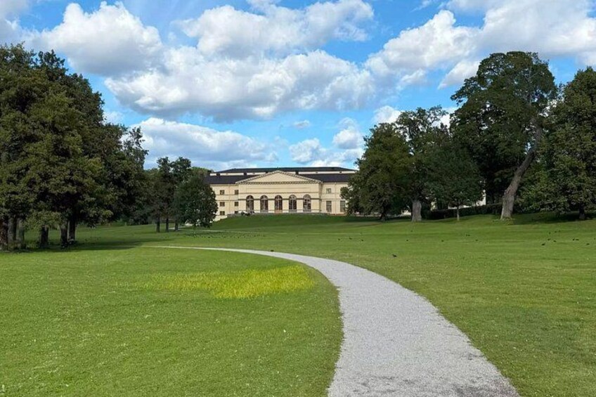 A pathway leading to a classical building surrounded by trees. 3