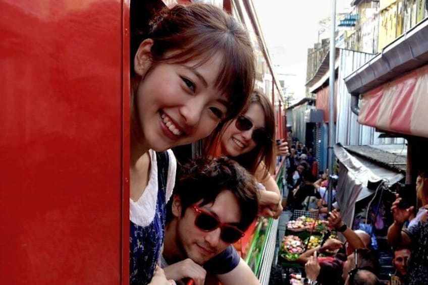 A narrow street with people and a red vehicle. 1
