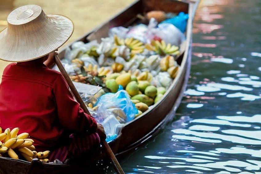 A person in a boat filled with various fruits and vegetables. 3