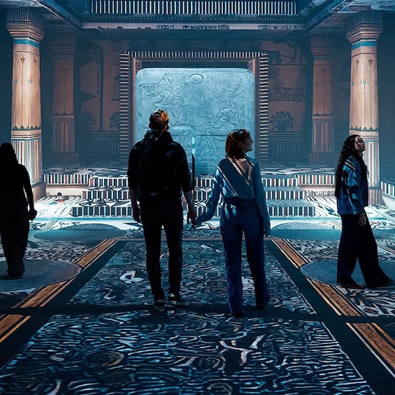 A grand hall with columns, a large ornate screen, and a patterned floor. 3