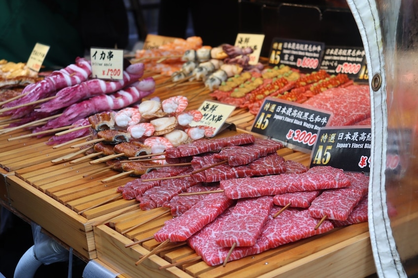 A variety of skewered meats and seafood at a market stall. 4