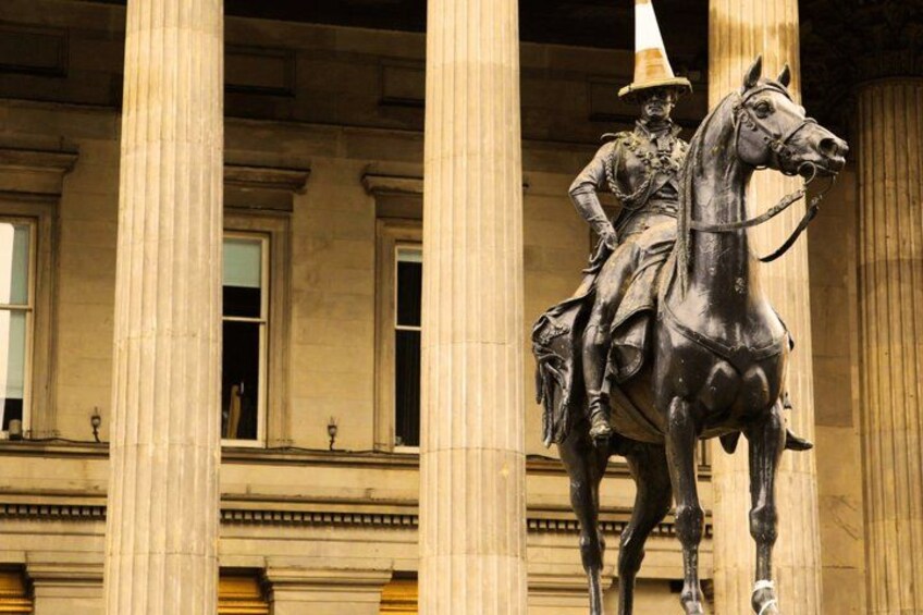 Statua di un cavaliere a cavallo di fronte a un edificio con colonne. 2