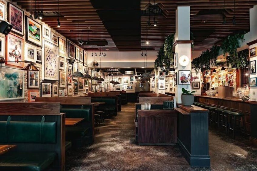 Een restaurantinterieur met zitjes, een bar en foto's aan de muur. 2