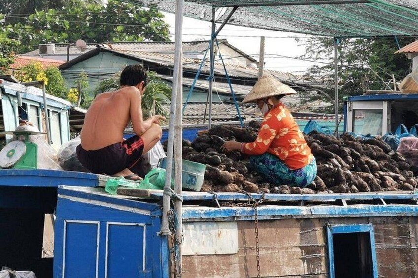 Two people sorting fish on a wooden structure with a blue door and a metal chain. 3