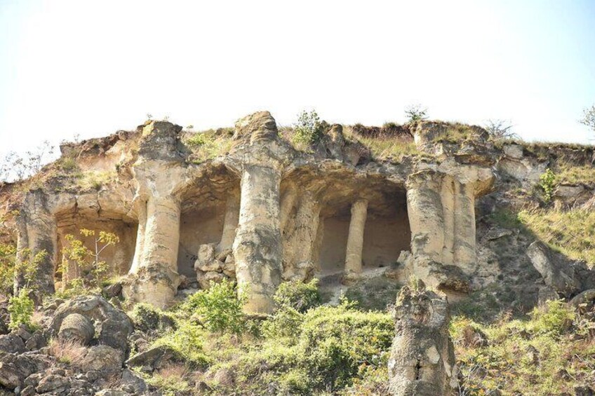 A rock formation with columns and a cave-like structure. 4