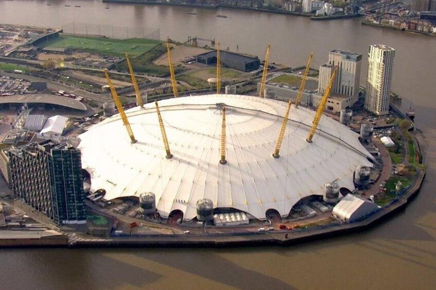 A large stadium with a white roof and four tall cranes. 4