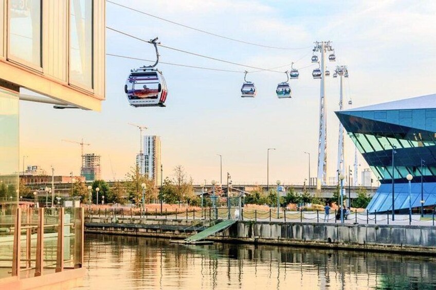 A cable car system, a modern building, and a water body. 2