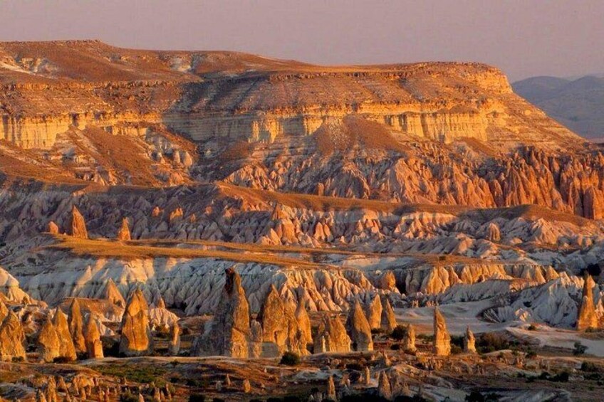 A rugged landscape with layered rock formations and distinctive spires. 4