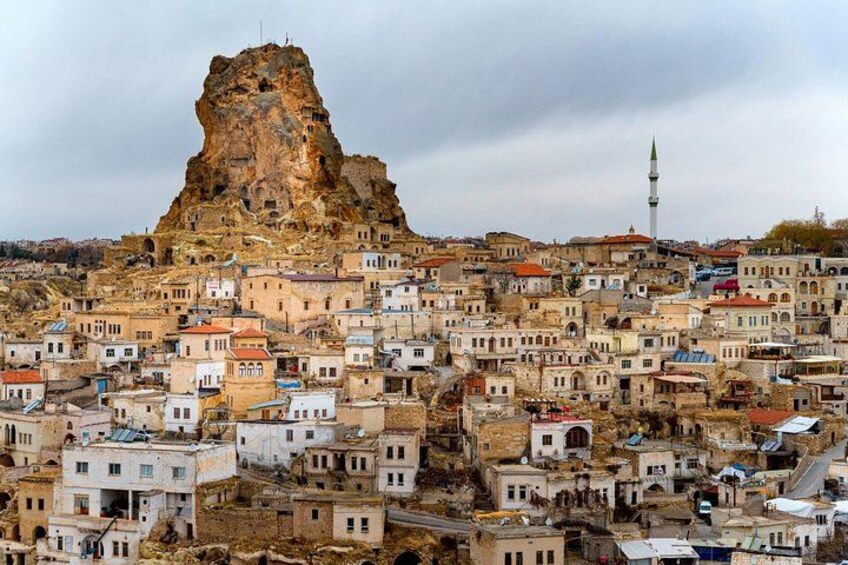 A town with a prominent rocky hill and a mosque. 2