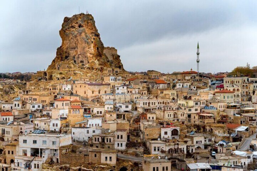 A town with a prominent rocky hill and a mosque. 2