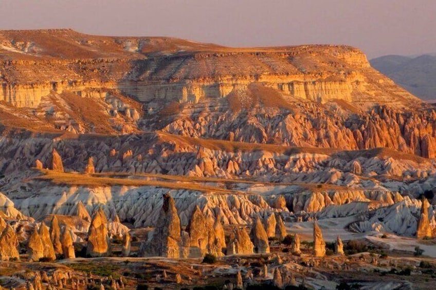 A rugged landscape with prominent rock formations and layered sedimentary cliffs. 4