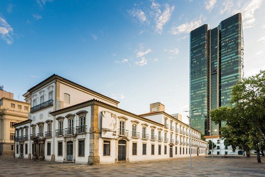 A historic building with classical architecture, a modern skyscraper, and a clear sky. 2